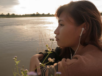 Portrait of young woman looking away outdoors