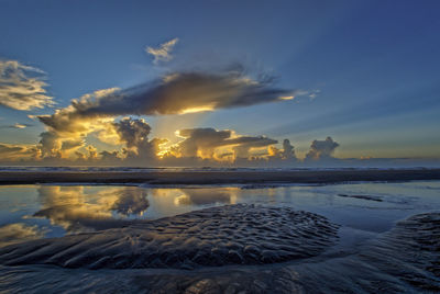 Scenic view of sea and beach against sky during sunrise 