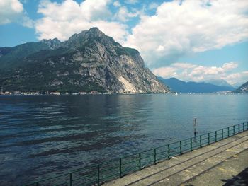 Scenic view of sea by mountains against sky