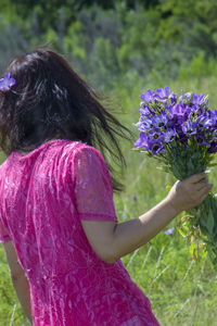 Woman with pink flower petals on field