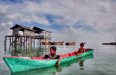 Men on boat in sea against sky