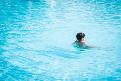 High angle view of boy swimming in pool