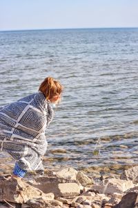 Rear view of woman looking at sea against sky