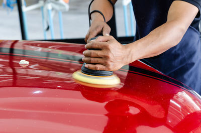 Midsection of man polishing car