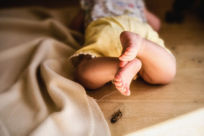 Low section of baby on bed