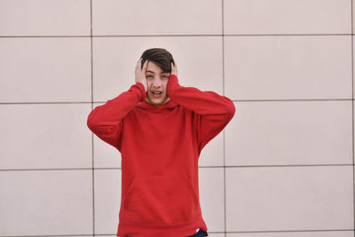 Young man standing against wall