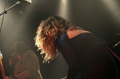 Midsection of woman at illuminated music concert