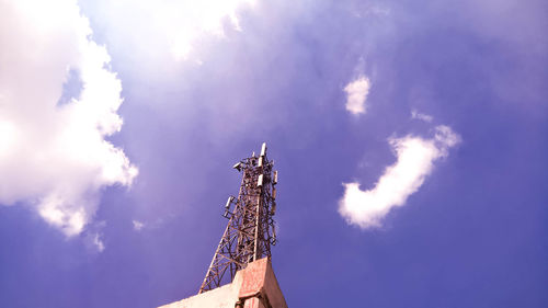 Low angle view of communications tower against blue sky