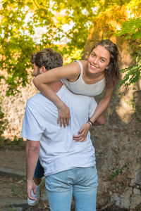 Man lifting woman on shoulder at park