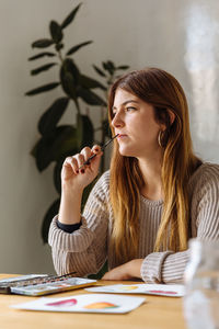 Artist thinking while drawing inside of home