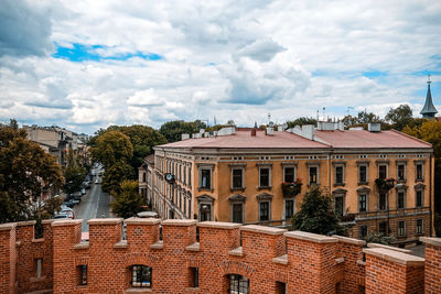 Houses in town against cloudy sky