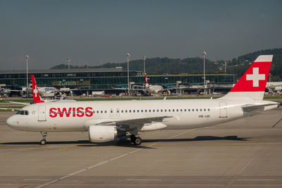 Airplane on airport runway against sky