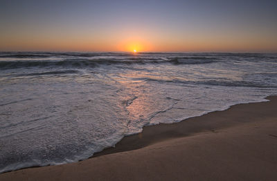 Scenic view of beach against sky during sunset