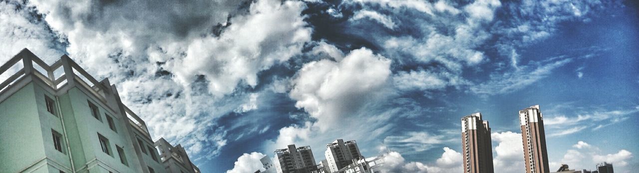 low angle view, architecture, built structure, building exterior, sky, cloud - sky, panoramic, city, cloud, high section, day, tall - high, outdoors, skyscraper, office building, city life, cloudy, modern, scenics, building story, beauty in nature, no people, tall, cloudscape