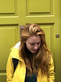 Front view of beautiful woman standing against door