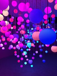 Multi colored balloons against illuminated lights at night