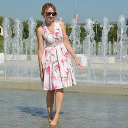 Woman walking on water at fountain during sunny day