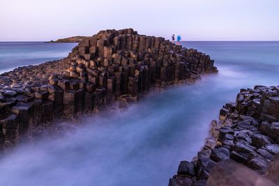 High angle view of rock formations amidst sea against sky