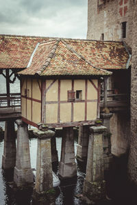 Exterior of old building by house against sky