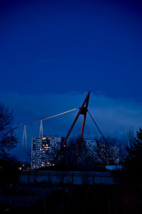 Illuminated city against blue sky at night