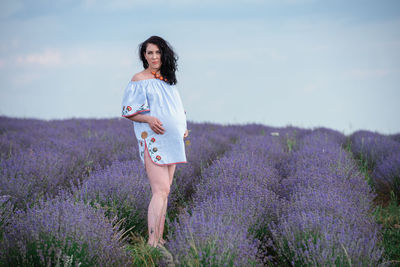 Full length of woman standing on field against sky