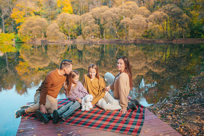 Group of people sitting in autumn forest