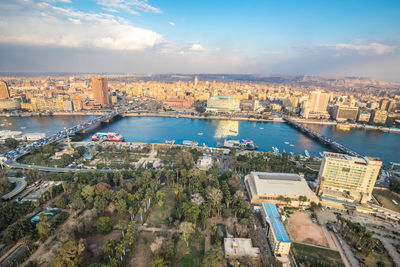 High angle view of river amidst buildings in city against sky