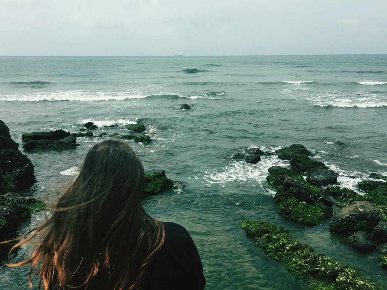 REAR VIEW OF WOMAN STANDING ON BEACH