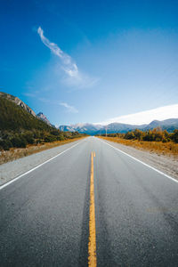 Road leading towards mountains against sky