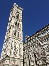 Low angle view of clock tower against blue sky