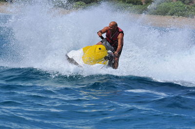 Full length of man riding jet boat in sea