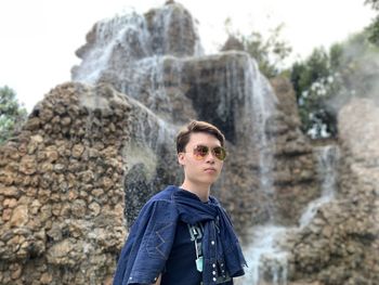Portrait of teenage boy standing on rock