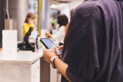 Midsection of man using mobile phone