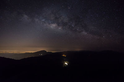 Scenic view of silhouette mountain against sky at night