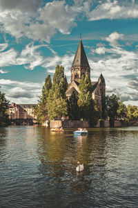 Building by lake against sky