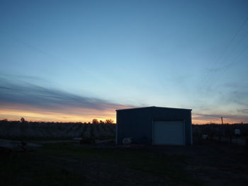 Built structure on landscape at sunset