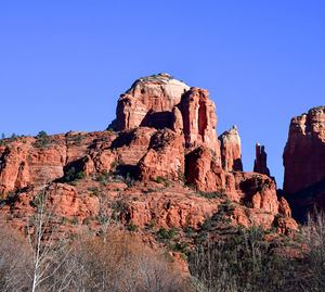 Low angle view of rock formations against clear blue sky