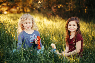 Friends playing with dolls on field