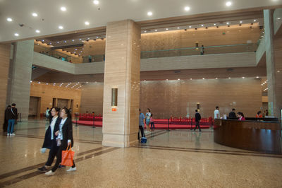 People walking in illuminated corridor