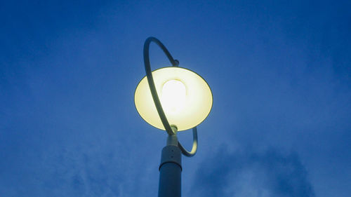 Low angle view of street light against blue sky