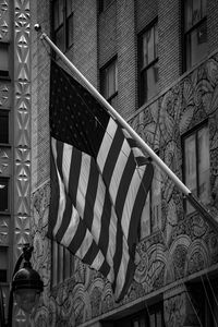 Low angle view of flag amidst buildings in city