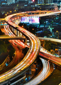 High angle view of light trails on elevated bridge in city at dusk