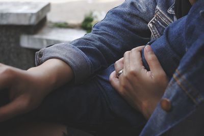 Midsection of couple holding hands