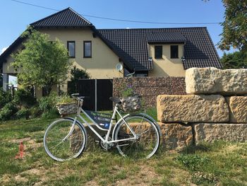 Bicycle outside house on field by building