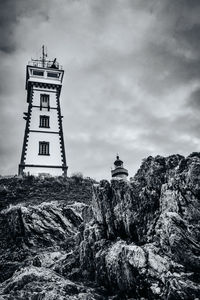 Low angle view of lighthouse amidst buildings against sky