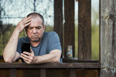 Portrait of man using mobile phone outdoors