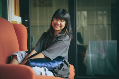 Asian teenager toothy smiling face ,relaxing in home living room