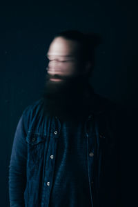 Blurred image of man against black background