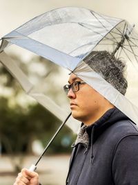 Portrait of young man holding umbrella