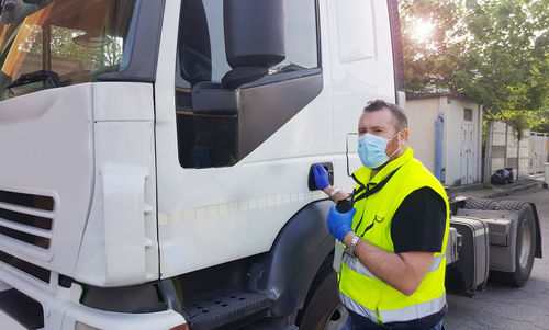 Man wearing mask standing by truck